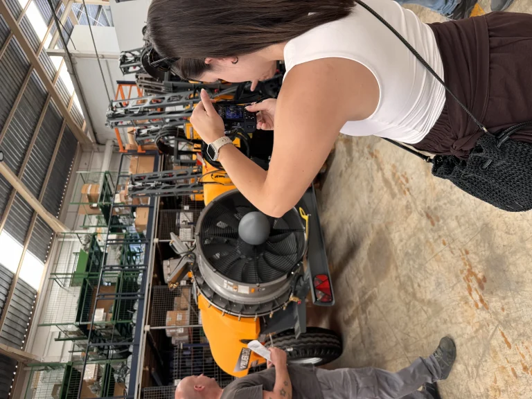 Andrea fotografiando maquinaria industrial en las instalaciones de un cliente